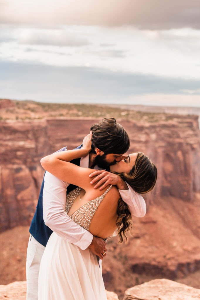 First kiss with a view! After their elopement ceremony at Canyonlands, Moab the groom dips his new wife for a smooch!