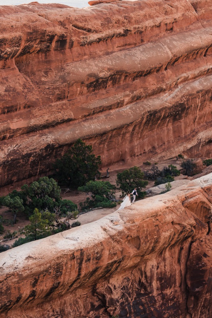 Arches National Park wedding, Moab, Utah. This gorgeous couple explore the dramatic red rocks of the Arches as they adventure on their wedding day.