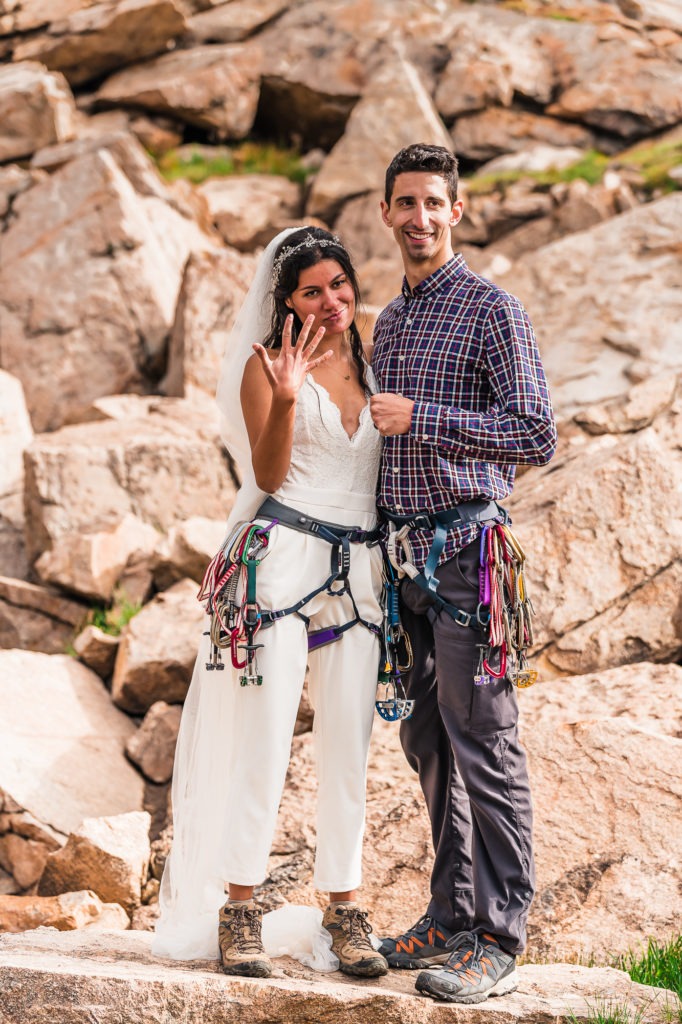 Rock climbing wedding. The bride wears a white jumpsuit with her harness over the top.
