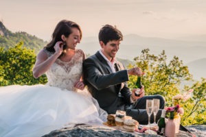 Hiking wedding picnic. The couple take some time out to relax and enjoy a champagne breakfast picnic.