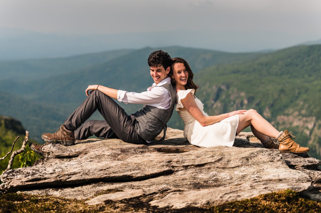 The couple relax bacb to back on a rock during their anniversary hiking adventure.