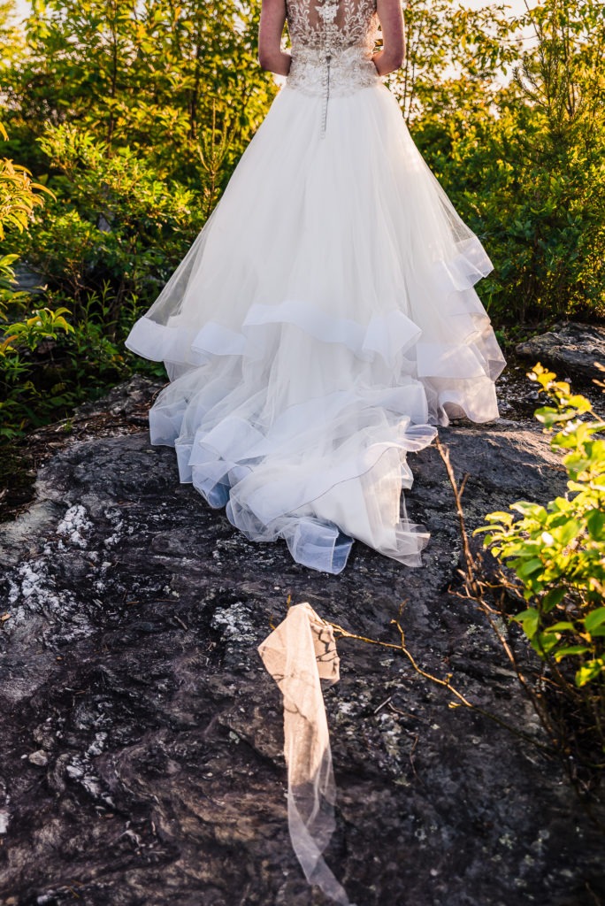 A scrap of the bride's white dress has ripped off on a thorn bush during her hiking adventure elopement.