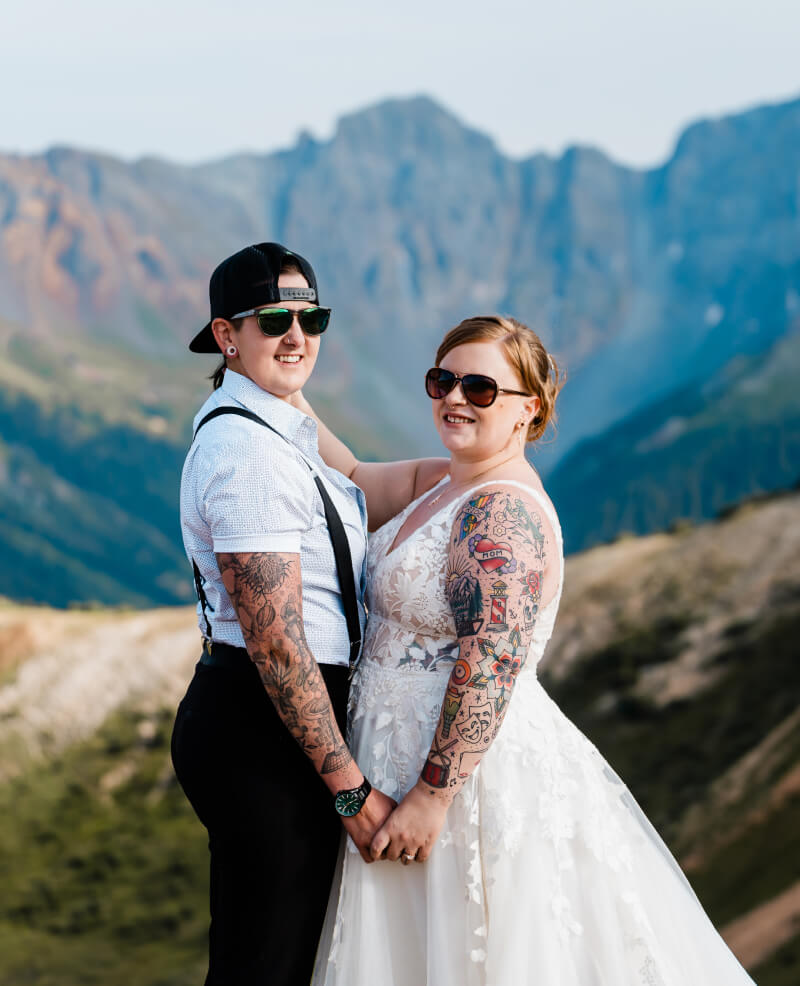 A couple holds hands while smiling at the camera.