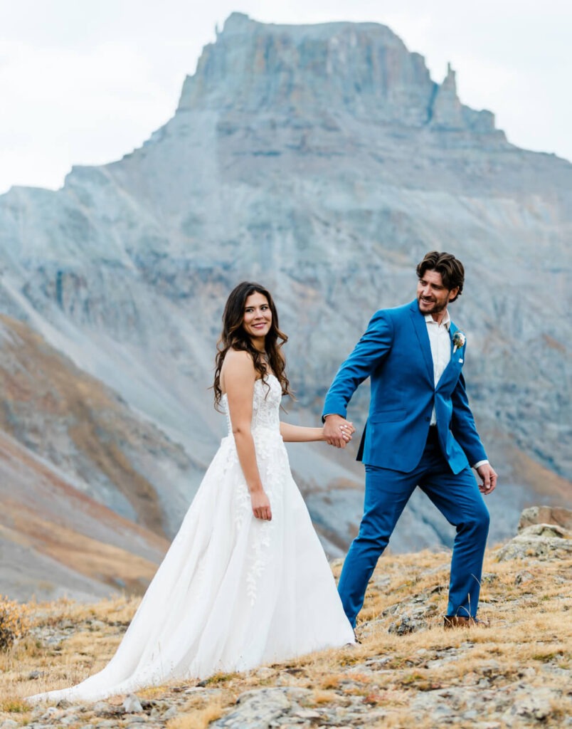 A couple walks happily surrounded by beautiful rocky landscapes.