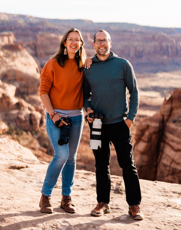 Vanessa and Chad smile while holding their cameras.