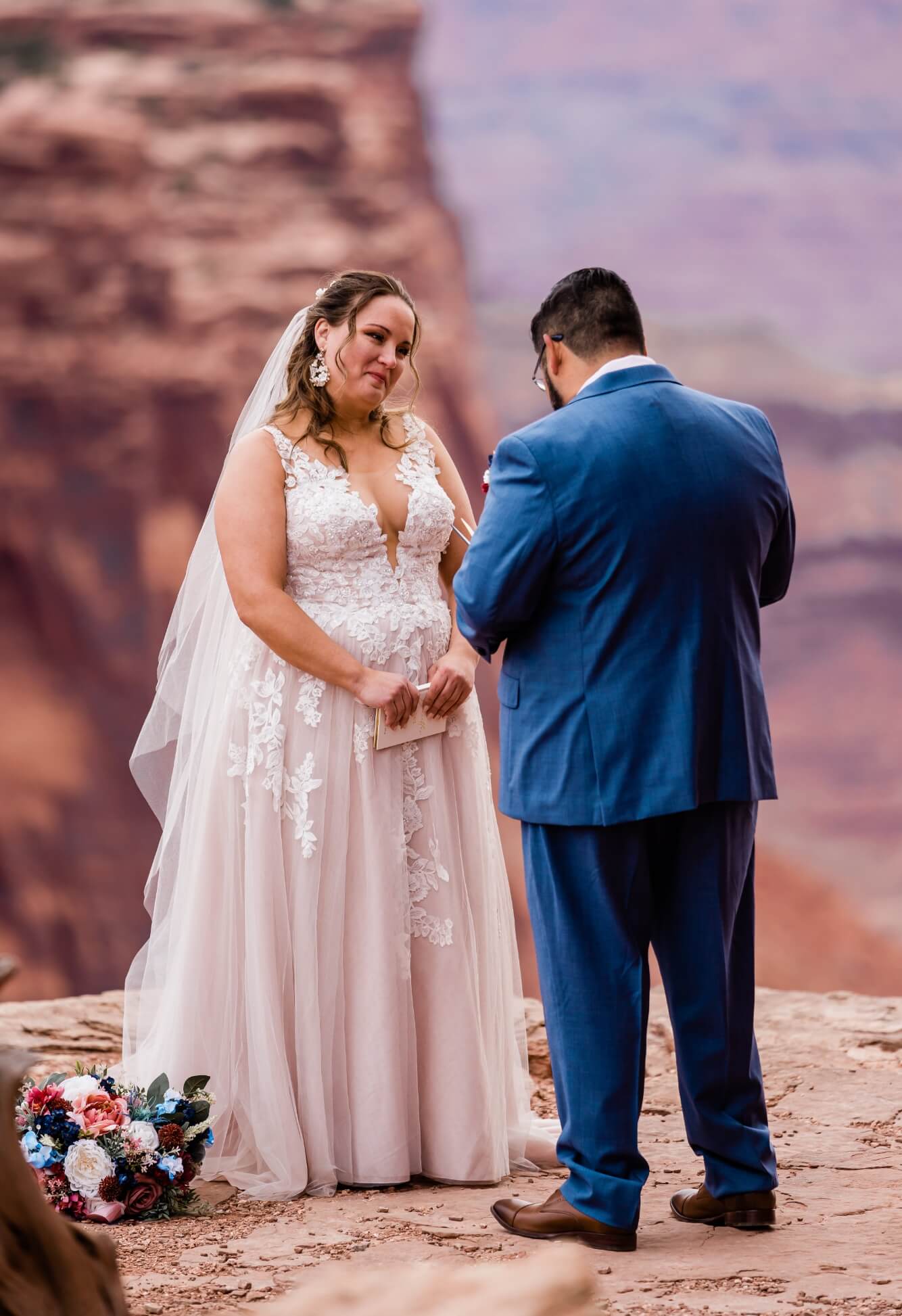 A couple cries as one of them reads vows in the desert.