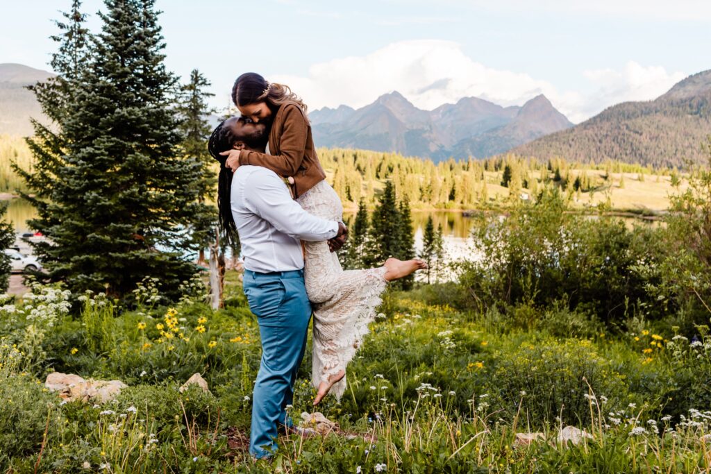 A person lifting up their parter as they kiss in a grassy field