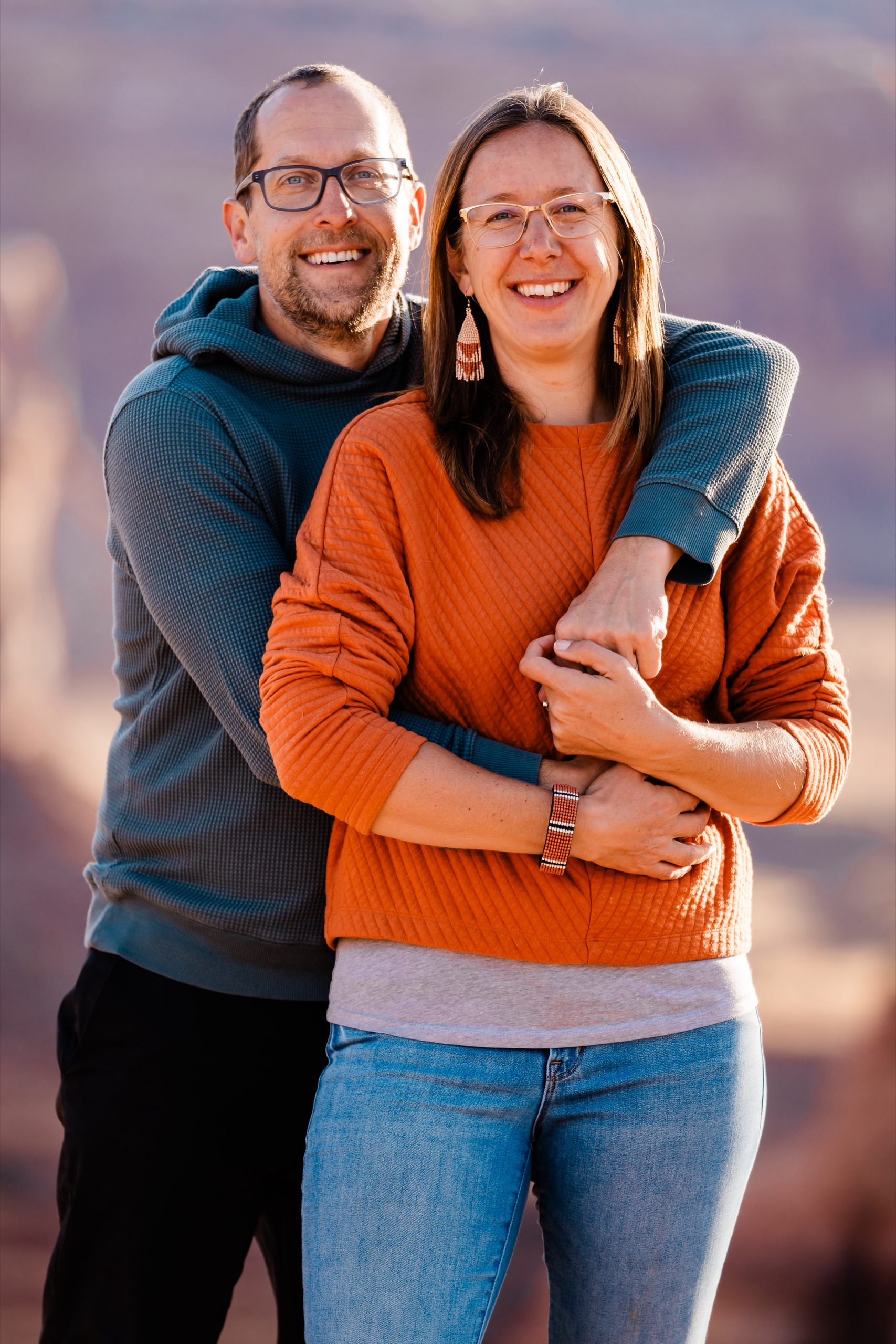 A couple with their arms around each other smiling together